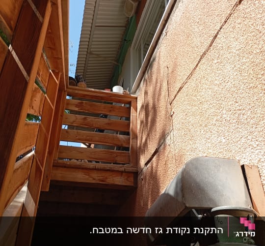 צילינדרים ירוקים ומבנה עץ ליד קיר חיצוני